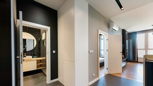 Une chambre d’hôtel moderne avec un mur d’accent de couleur sombre, un grand miroir et une vue sur la ville.