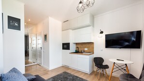 A modern living room with a grey sofa, a coffee table, and a TV mounted on the wall.