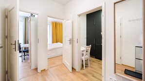 A modern apartment with a wooden floor, a bed, a desk, and a dining area. - Służewiec Comfort Zone Apartment (Warszawa)