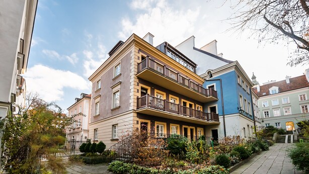 A multi-story residential building with a central courtyard, balconies, and a mix of architectural styles. - Mostowa Abdank Old Town Apartment (Warszawa)