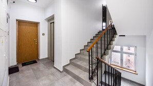 Ein modernes Interieur mit einer Holztür, einer Treppe mit Metallgeländer und einem Fenster mit Blick.