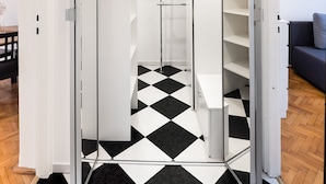 Ein modernes Interieur mit Schachbrettfußboden, einem Spiegelkleiderschrank und einem minimalistischen Design.