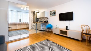 Un apartamento moderno con cocina, comedor y televisor montado en la pared.