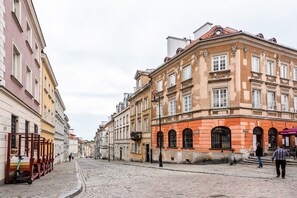 A cobblestone street lined with historic buildings featuring classic architecture and a clear sky. - Old Town Basilisk Apartment (Warszawa)