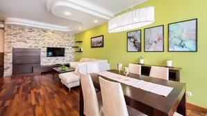 A modern living room with a dining area, a fireplace, and artwork on the walls.