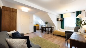 Une chambre d’hôtel moderne équipée d’un canapé, d’une table à manger, d’un lit et d’un téléviseur.