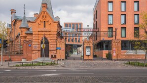 A historic building with a modern extension, featuring a prominent entrance and signage for 'Koneser'. - Arte Praga Koneser Apartment (Warszawa)