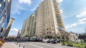 Un immeuble résidentiel à plusieurs étages, doté d’une architecture moderne, de balcons et de grandes fenêtres.