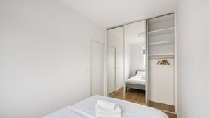 Une chambre à coucher avec un lit, une armoire et un miroir.