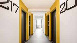 Ein Flur mit den Fenstertüren 217 und 20, der zu einem hellen Raum am Ende führt.