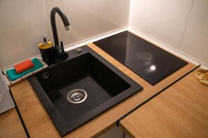 Enjoy cooking in this well-equipped kitchen with a black sink, stovetop, and ample counter space.