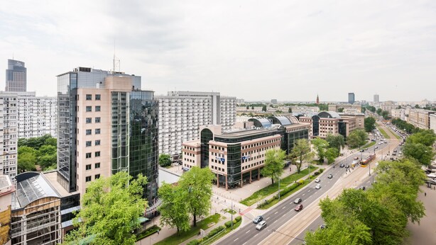Ein modernes Stadtgebiet mit Hochhäusern, einer zentralen Kreisverkehr und einer Mischung aus Gewerbe- und Wohngebäuden.