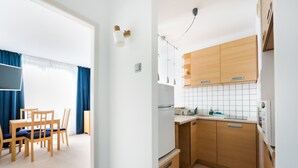 Eine moderne Küche mit Holzausstattung, einer weißen Arbeitsplatte und einem eingebauten Backofen.