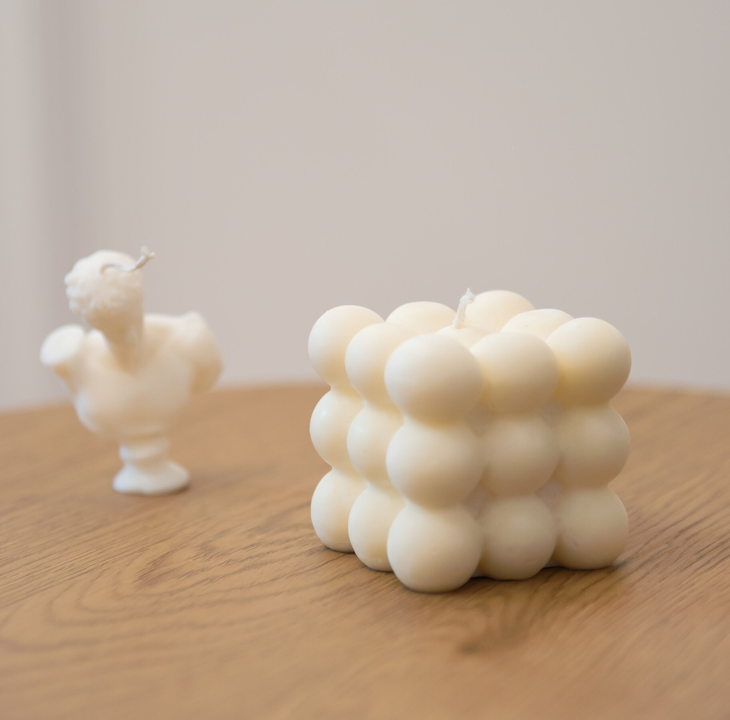Une table en bois sur laquelle se trouvent un objet sphérique blanc et une petite figurine blanche.
