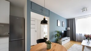 Eine moderne Küche mit Einbaukühlschrank, einem Holztisch und einer Topfpflanze.