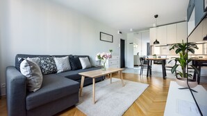 Ein modernes Wohnzimmer mit einem grauen Sofa, einem Holztisch und einem weißen Teppich.