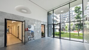 Un moderno vestíbulo de hotel con una pared de mármol, una entrada con puerta de cristal y vistas a la ciudad.