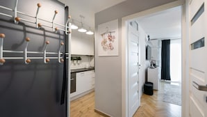 A modern kitchen with white cabinets, a wooden countertop, and a hanging plant.