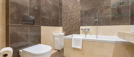 A modern bathroom with a toilet, sink, and shower area.