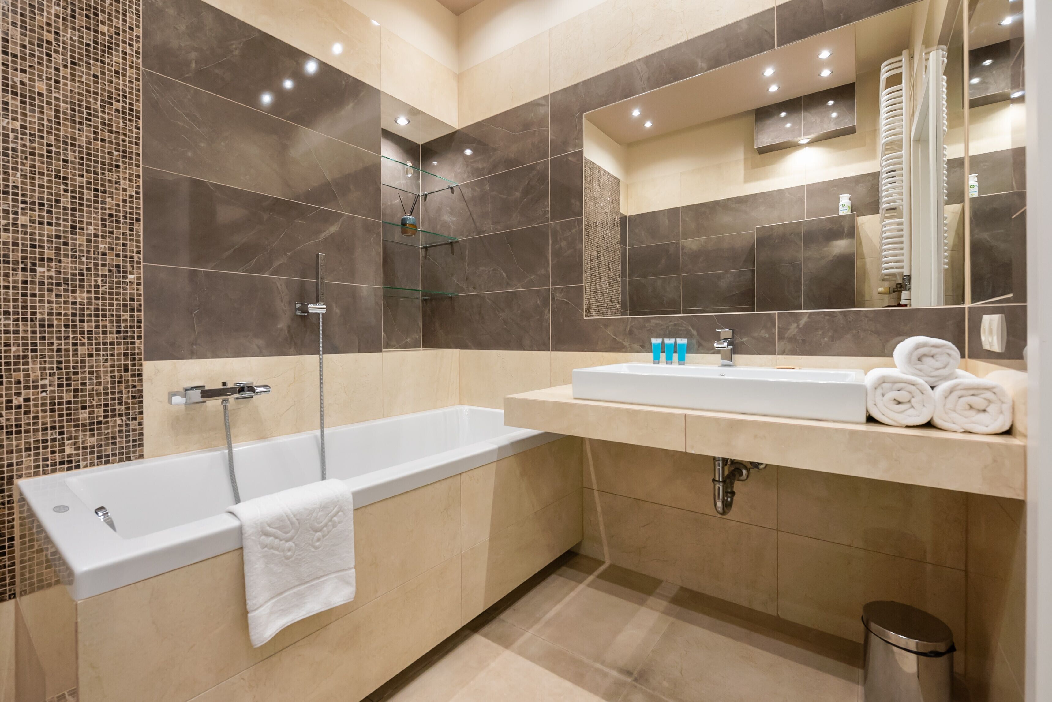 A modern bathroom with a bathtub, a sink, and a mirror.