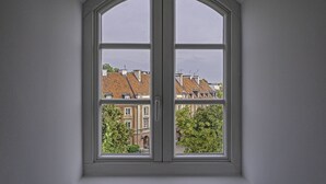 Une fenêtre donnant sur des immeubles et des arbres.
