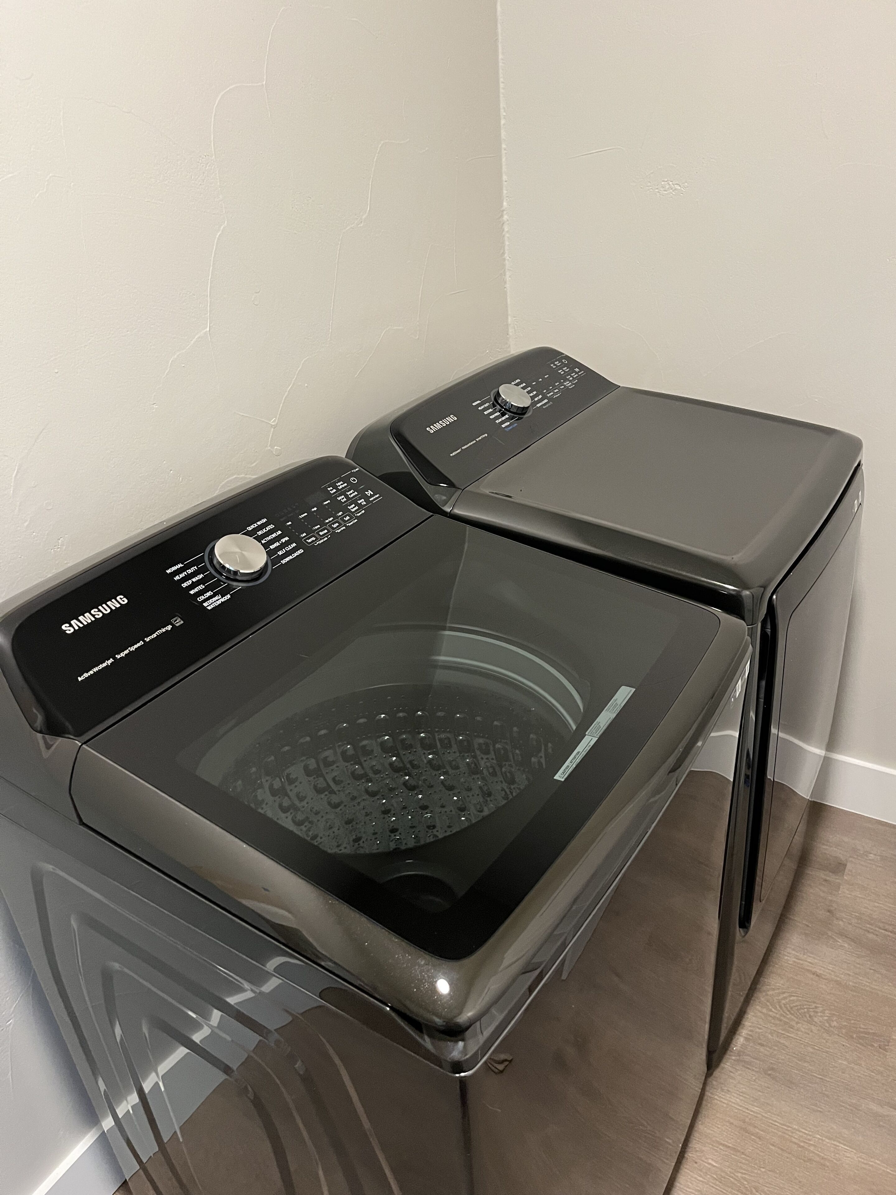 A Samsung front-loading washing machine with a transparent door, control panel, and a stainless steel top.