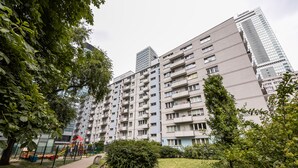 A residential building with multiple balconies, a playground, and a well-maintained garden area.