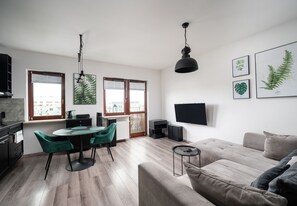 Relax in this stylish living space with a round dining table, comfortable sofa, and flat-screen TV.