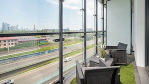 Uma varanda com vista para uma rodovia e a paisagem urbana.