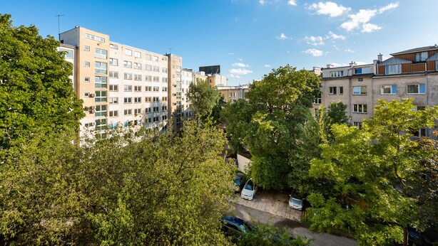 A residential area with multi-story buildings, trees, and parked cars. - Spiska Standard Studio (Warszawa)