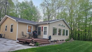 Une maison à deux étages avec un porche, un patio couvert et une pelouse bien entretenue.