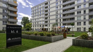 A modern apartment building with a playground area in front. - Lotnisko Chopina Modern Apartment (Warszawa)