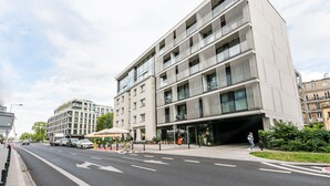 A modern multi-story building with a flat facade, large windows, and a covered entrance area. - Centrum Nauki Kopernika Luxury Studio (Warszawa)