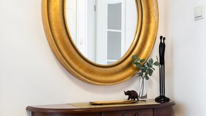 A round mirror with a gold frame on a wooden console table. - KEN 54 2-Bedroom Apartment (Warszawa)