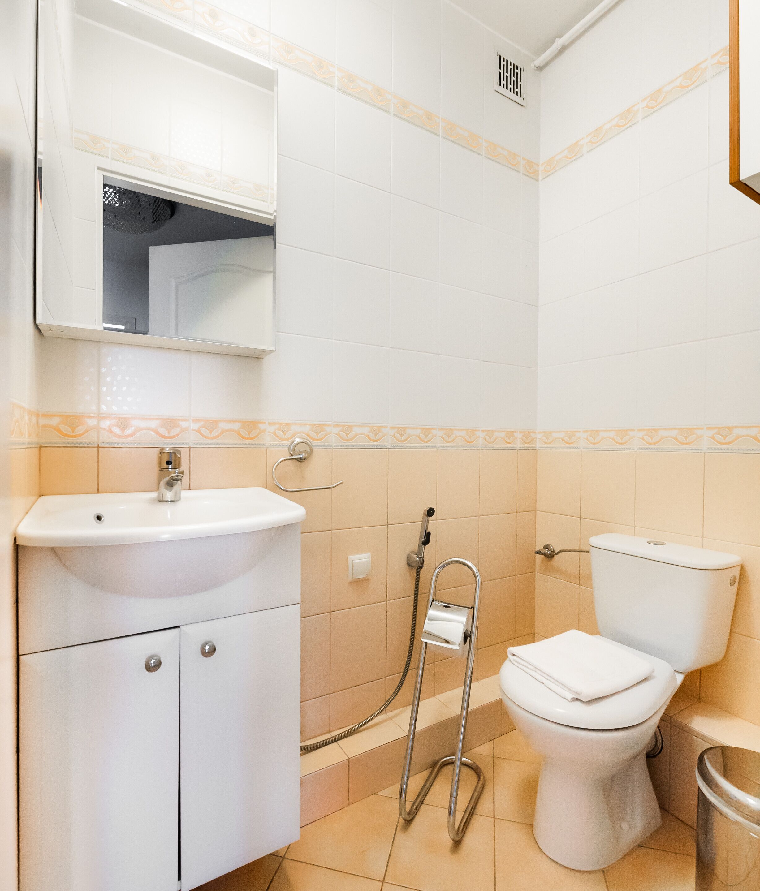 Et badeværelse med hvid vask, toilet og brusebad.