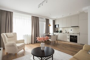Un salon moderne avec un canapé, une table basse ronde et un coin repas comprenant des chaises et une table.