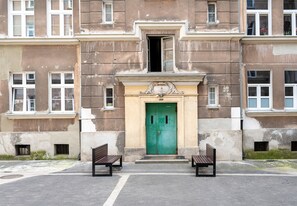 A building with a green door, two benches, and a small entrance. - Metro Wileński Varsovia Studio #2 (Warszawa)