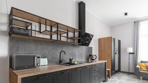 A modern kitchen with a microwave, toaster, sink, and cabinets.