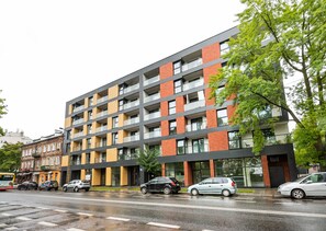 Un immeuble à plusieurs étages doté d’une architecture moderne, caractérisé par une combinaison de façades en brique et en verre.