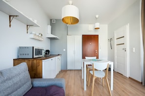A compact living space with a kitchenette, a dining area, and a separate sleeping area.