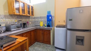 A kitchen with wooden cabinets, a microwave, a coffee maker, and a refrigerator.