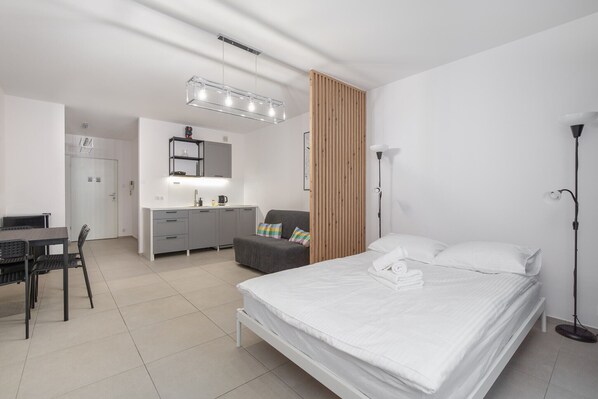 Una habitación de hotel moderna con cama, mesita de noche, escritorio y silla.