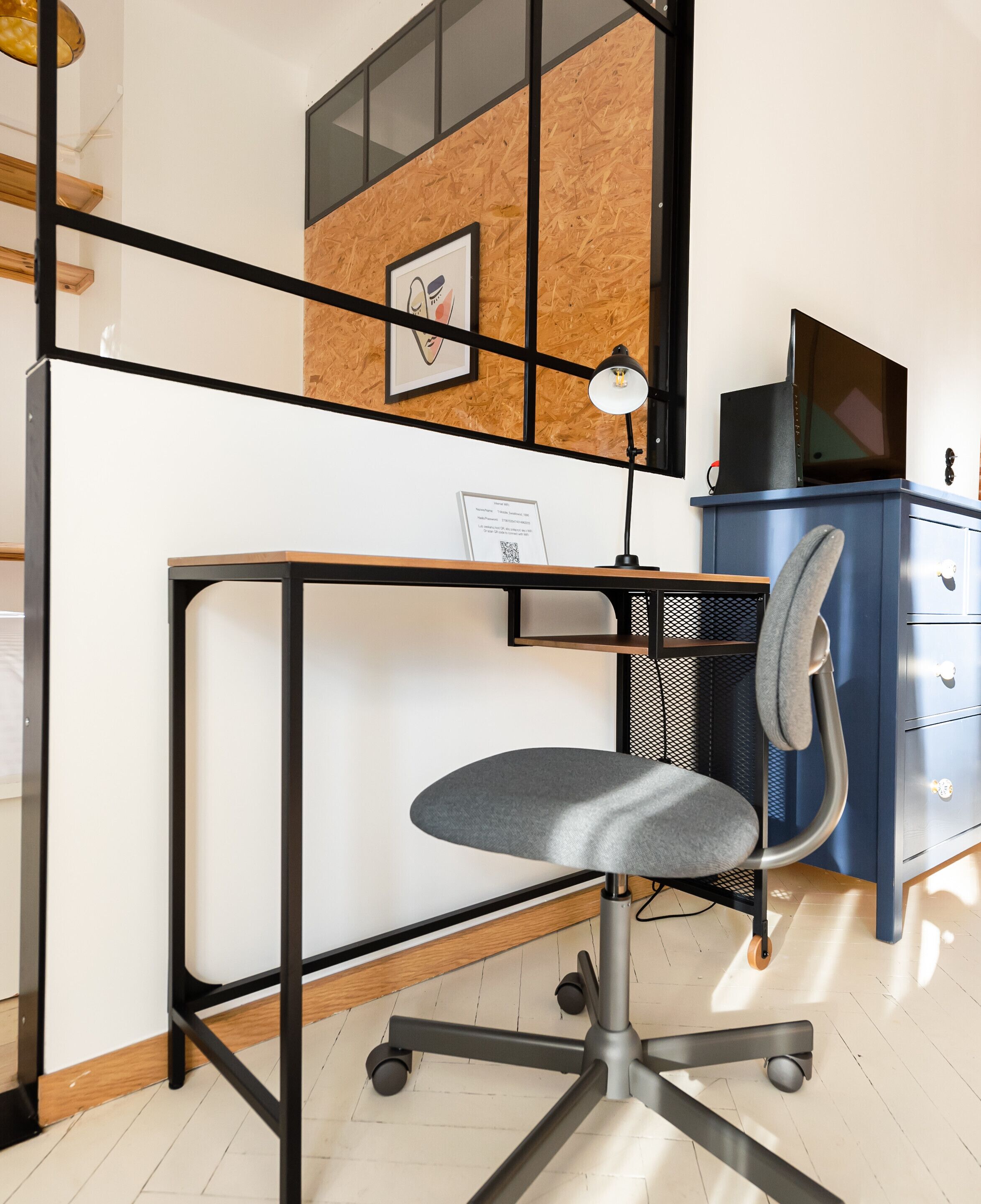 A modern office space with a desk, chair, and a blue cabinet.
