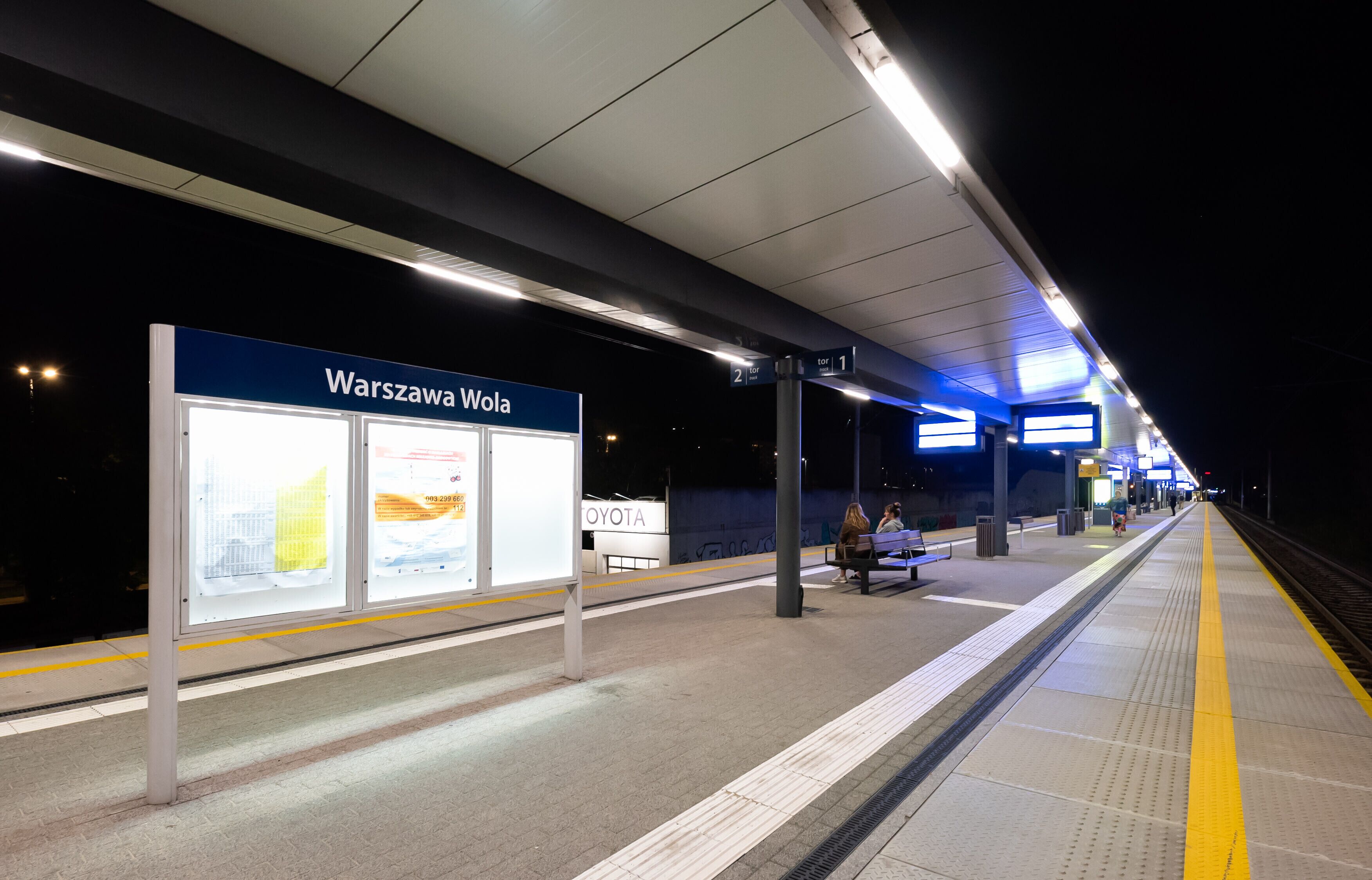 Un quai de gare avec un panneau indiquant « Varsovie Wola ».