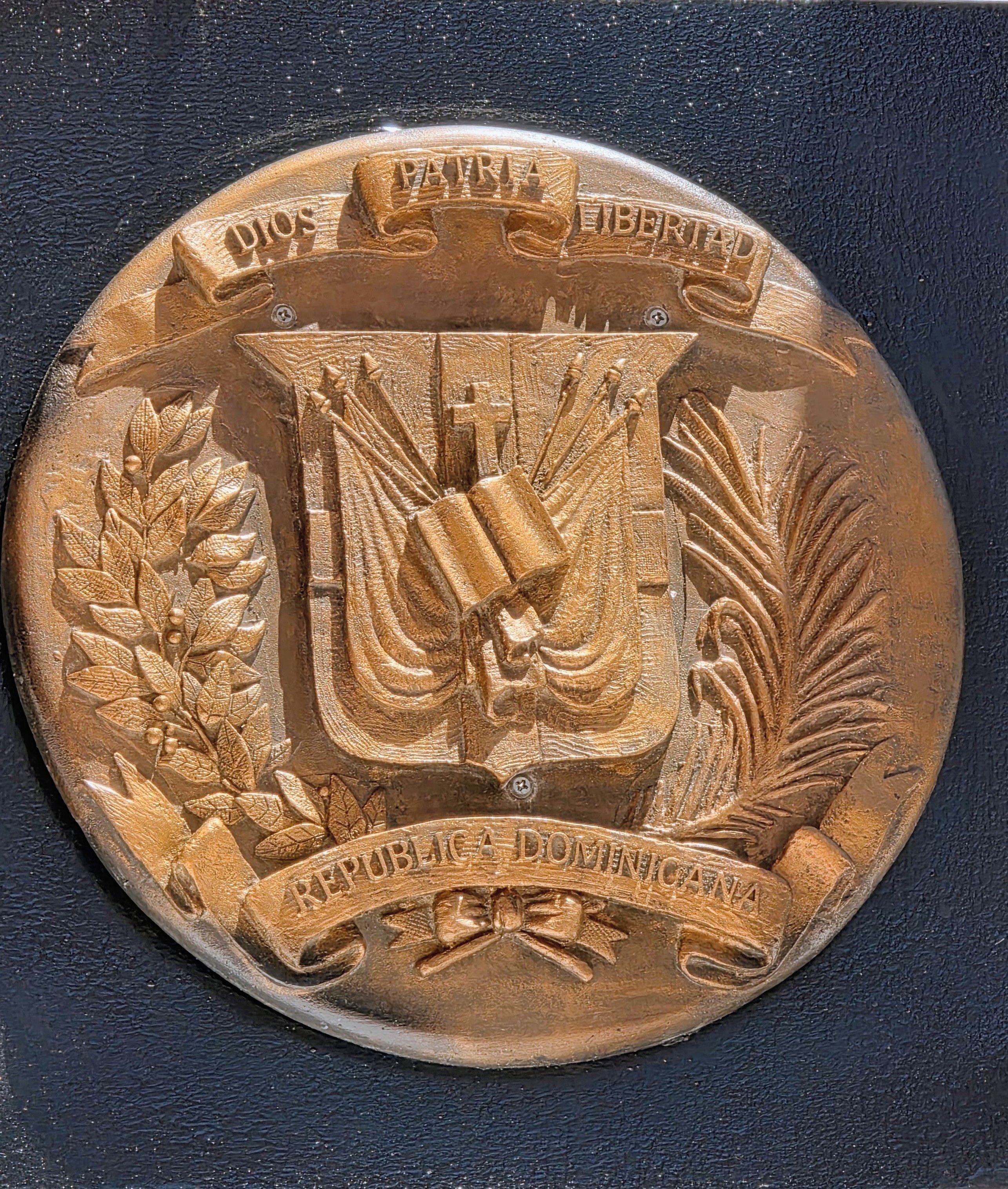 A circular object with embossed text and a central emblem.