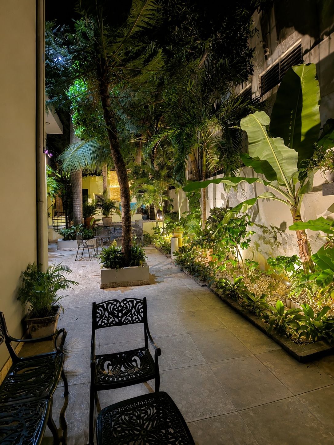 An outdoor patio area with seating, potted plants, and a stone pathway.