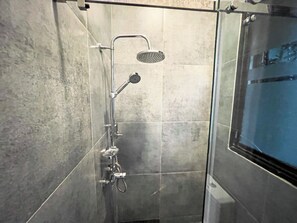 Deluxe studio | Badkamer | Een douche, een haardroger, handdoeken