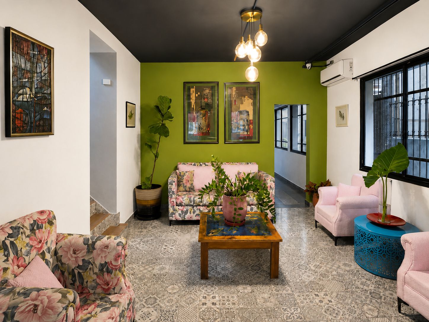 A living room with a green accent wall, a sofa, a coffee table, and a large window.
