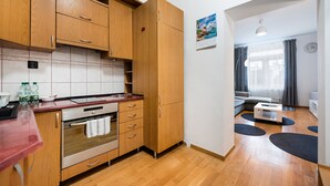 Una cocina moderna con armarios de madera, horno integrado y encimera roja.