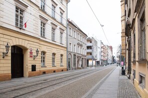 Eine Straße mit Gebäuden, einer Straßenbahnschiene und einem Bürgersteig.